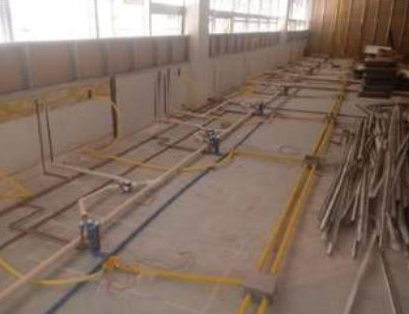Tubulações elétricas e hidráulicas no piso do laboratório, antes do acabamento