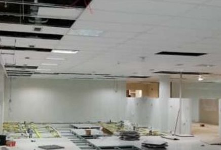 Ambiente com forro em montagem e instalações aparentes