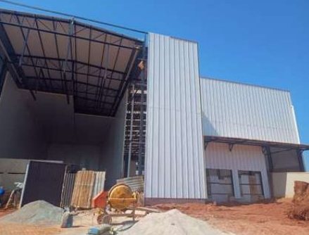 Fachada do galpão com painéis metálicos durante a obra