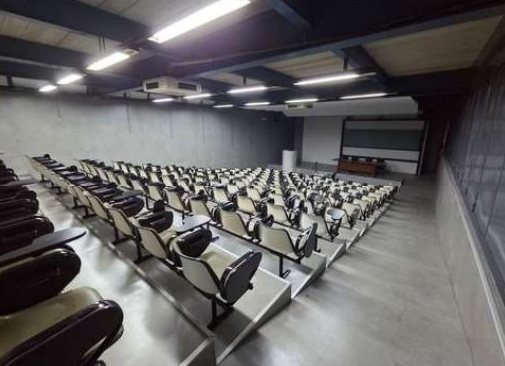 Auditório reformado, com poltronas e iluminação em linha
